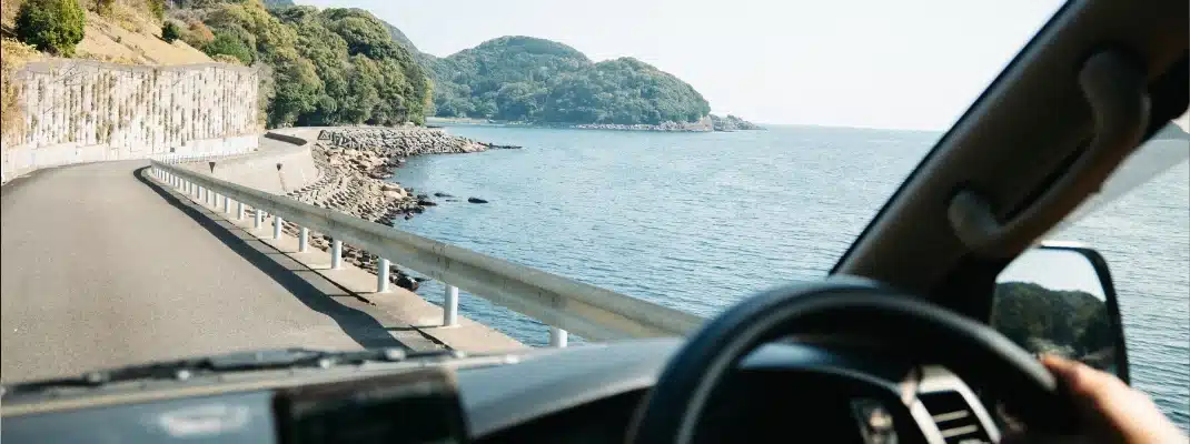 Driver's point of view driving a campervan along a scenic coastal road next to the sea in Kii peninsula